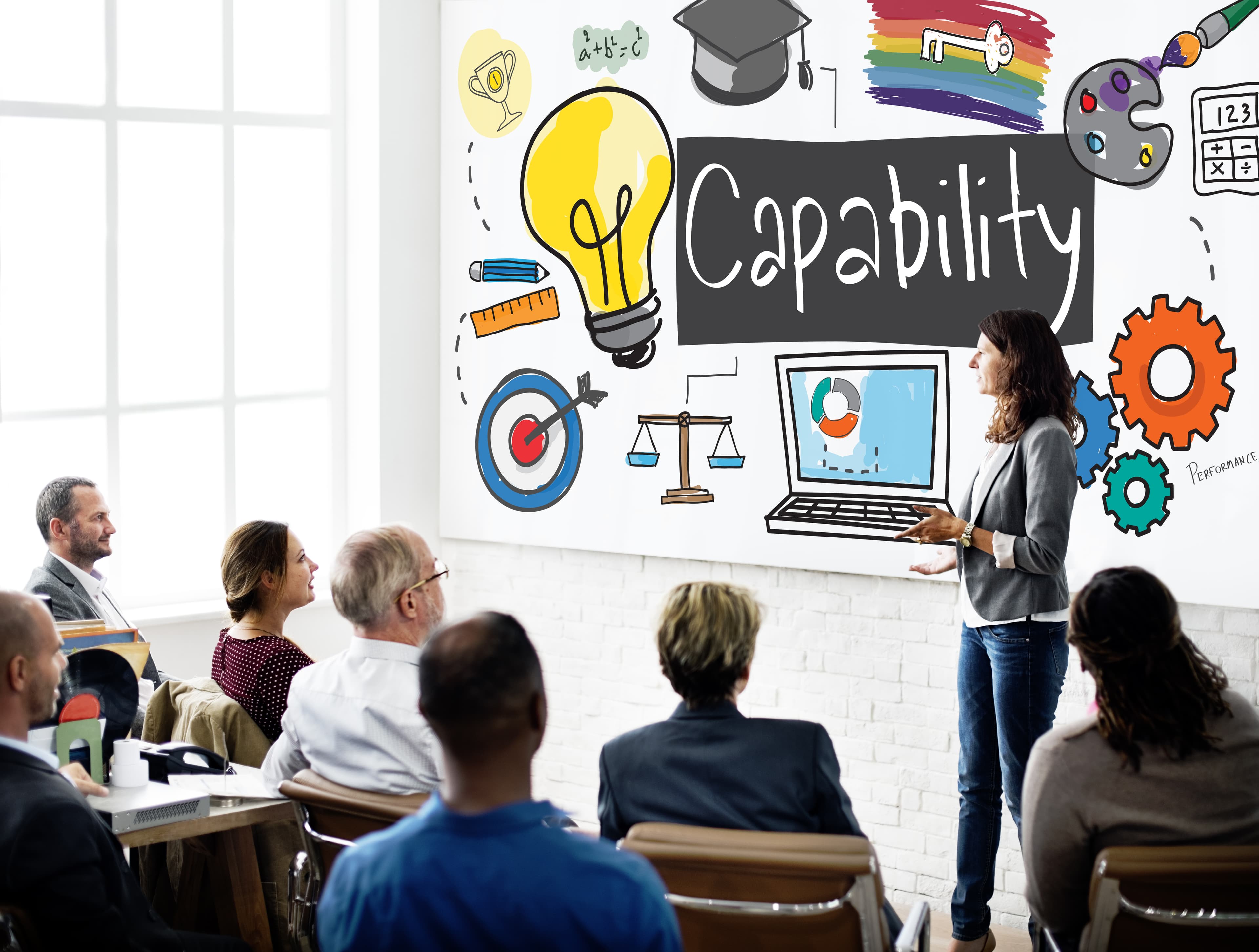 Capability gap assessment workshop with notes and diagrams spread across a table.